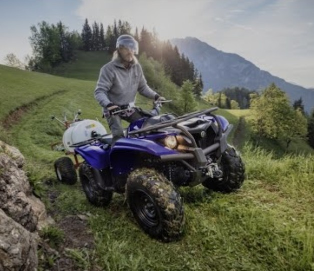 Man on a blue Four Wheeler bike
